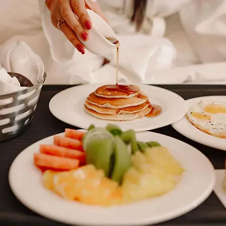 Radisson Blu Hotel Amritsar Exterior photo A woman pouring maple syrup on a stack of pancakes